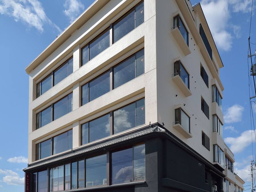 Un hôtel à plusieurs étages, doté d’une façade sobre, de grandes fenêtres et d’un hall d’entrée noir.