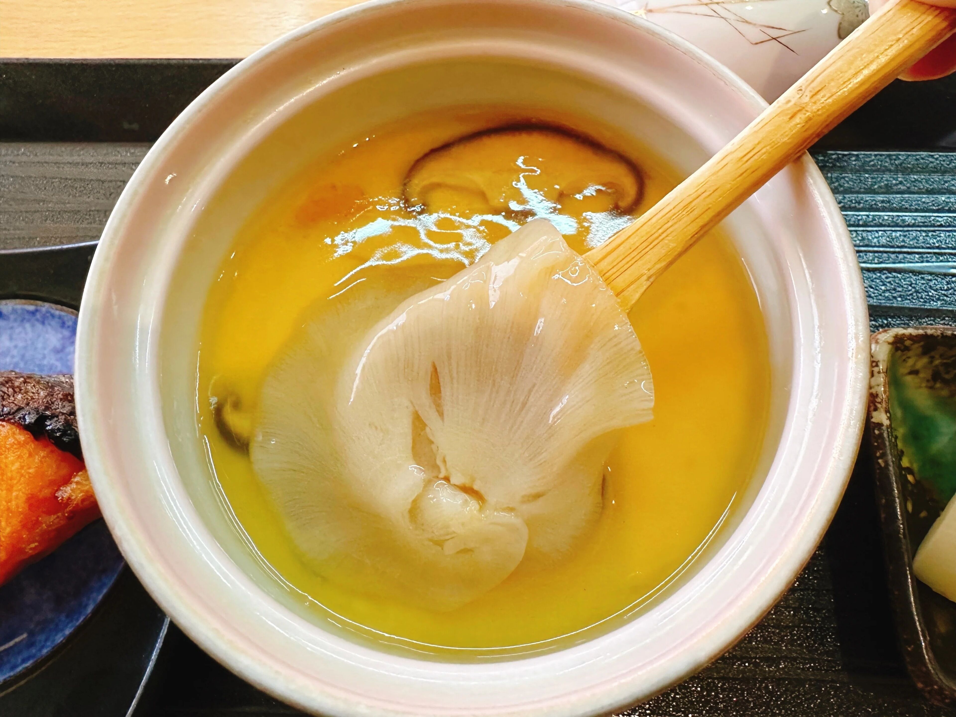 A bowl of soup with a wooden spoon.
