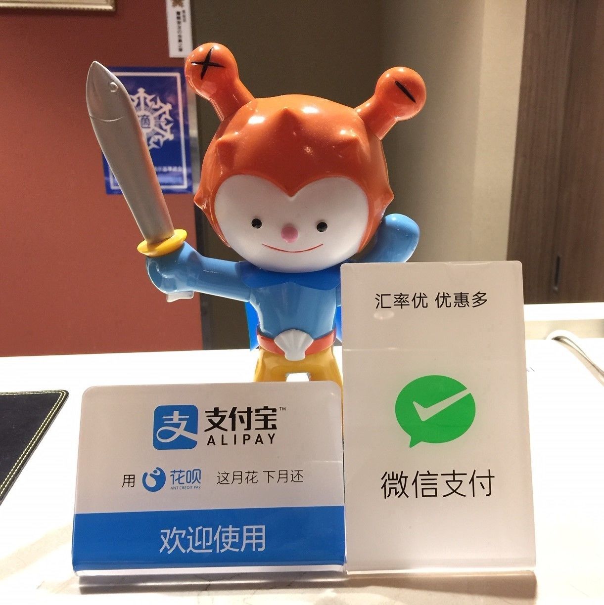 A figurine of a character holding a sword, a sign with Chinese text, and a card with a green checkmark.