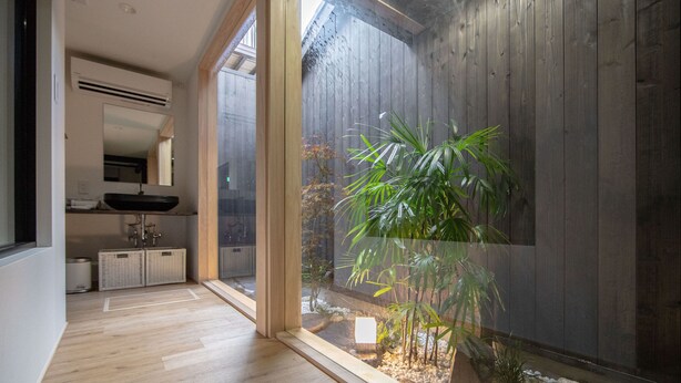 Een modern interieur met een houten vloer, een groot raam en een kamerplant.