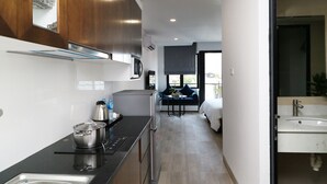 Een moderne keuken met roestvrijstalen apparatuur, een zwart aanrecht en houten kastjes.