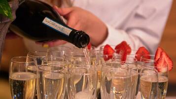 En person hælder champagne i glas med jordbær.