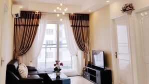 A modern living room with a sofa, coffee table, TV stand, and decorative elements. - Florita SGN Green Living (Ho Chi Minh City)