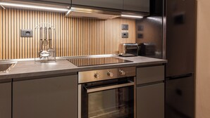 A modern kitchen with stainless steel appliances, a built-in oven, and a microwave. - Santa Croce Retreat by MMega (Florence)