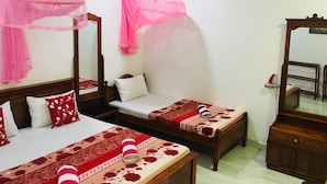 Habitación de hotel con dos camas, cada una con dosel, un aparador de madera, un espejo y una mesita de noche.