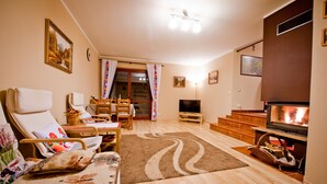 A cozy living room with a fireplace, comfortable seating, and a television.