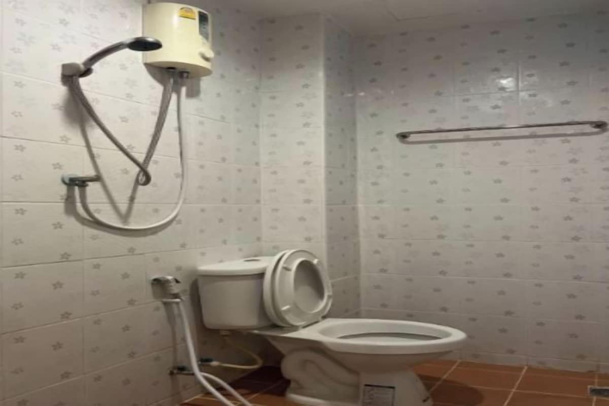 Un baño con inodoro, ducha y secador de manos.