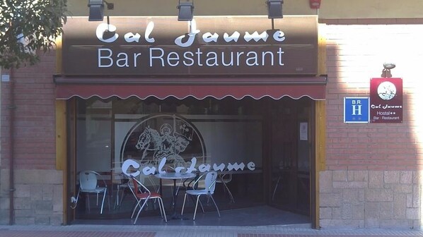 The exterior of Cal Jaune Bar Restaurant with a clear sign, a logo, and a few chairs outside. - Hostal Cal Jaume (Mollerussa)