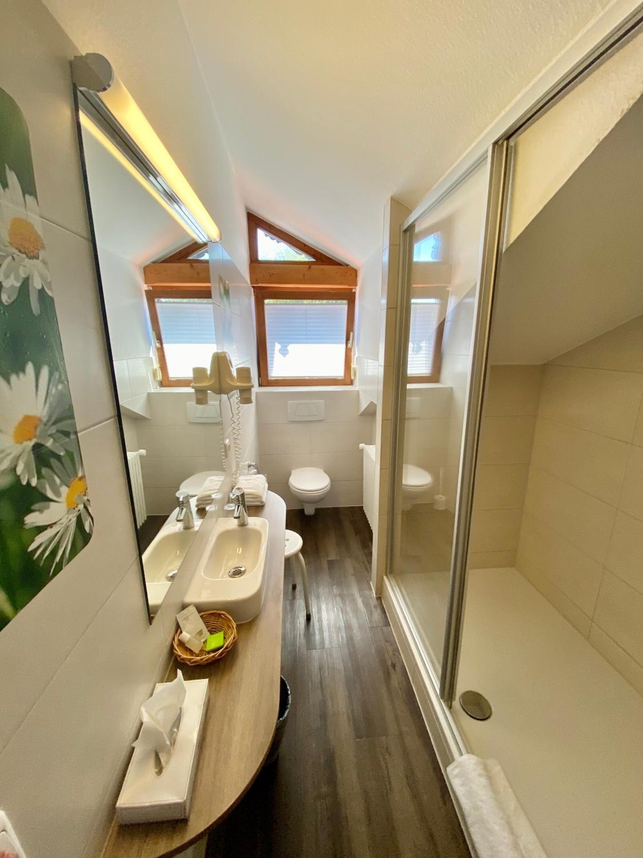 Un baño pequeño con lavamanos, inodoro y ducha.