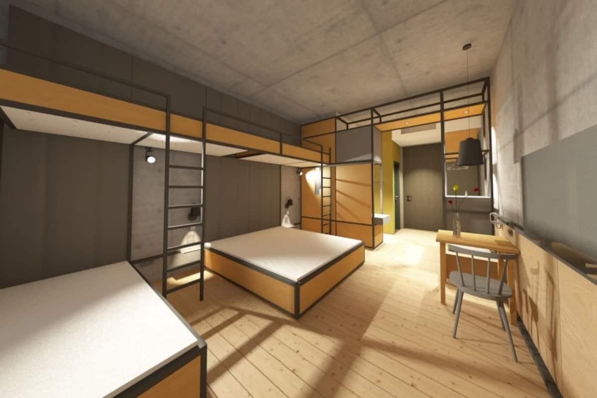A modern, minimalist room with a large bed, a desk, and a chair.