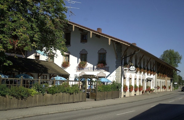 A traditional European building with a white facade, multiple windows, and a sign indicating it is a restaurant. - Gasthof-Hotel Hoehensteiger (Rosenheim)