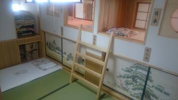 Um quarto japonês tradicional com tatames, escada e biombos shoji.