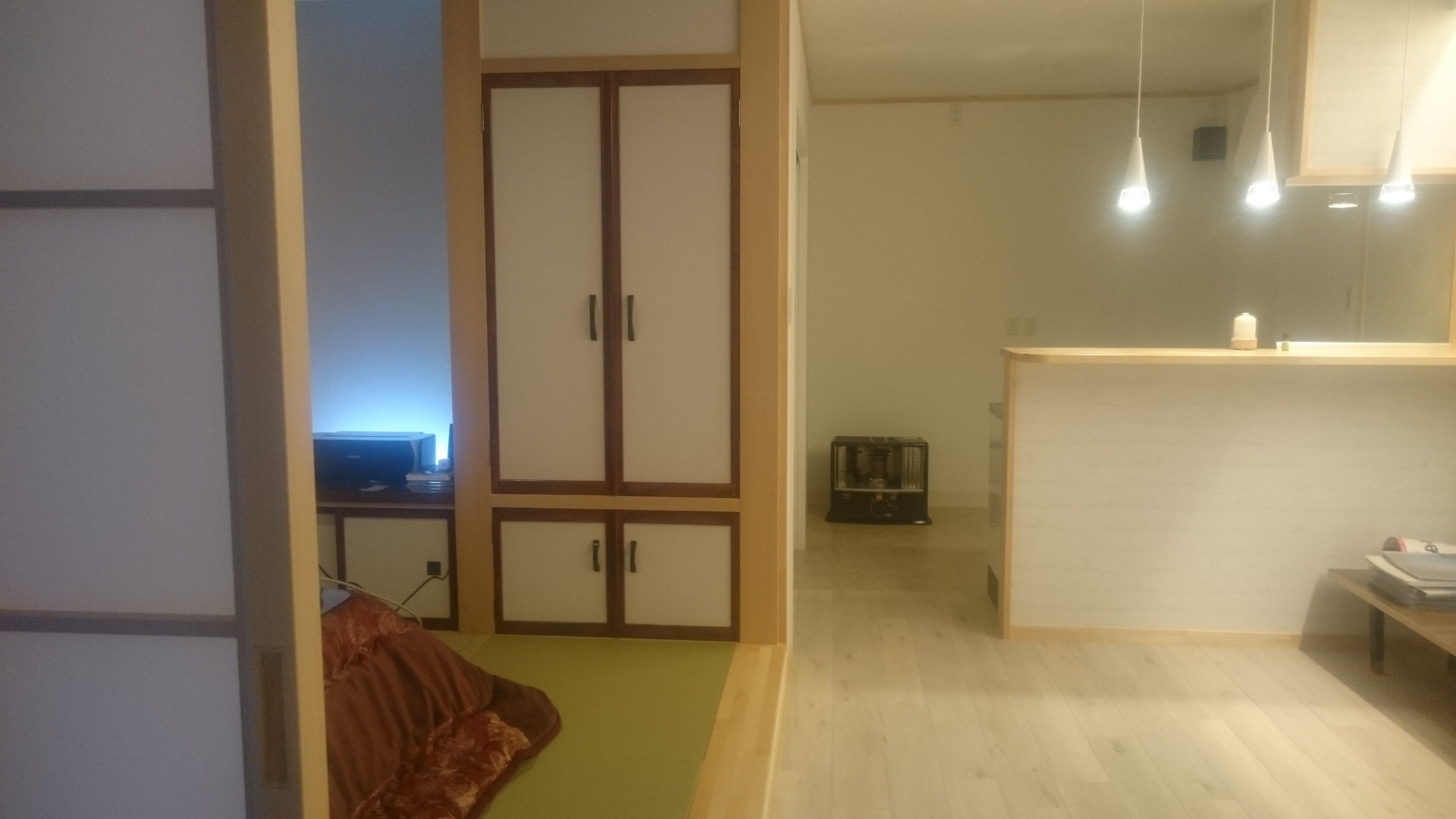 A room with a wardrobe, a desk with a computer, and a small table with a candle.