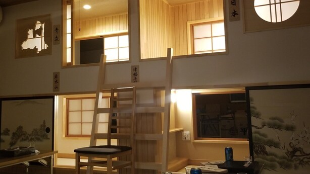 Una habitación japonesa tradicional con suelo de tatami, una escalera y puertas correderas.