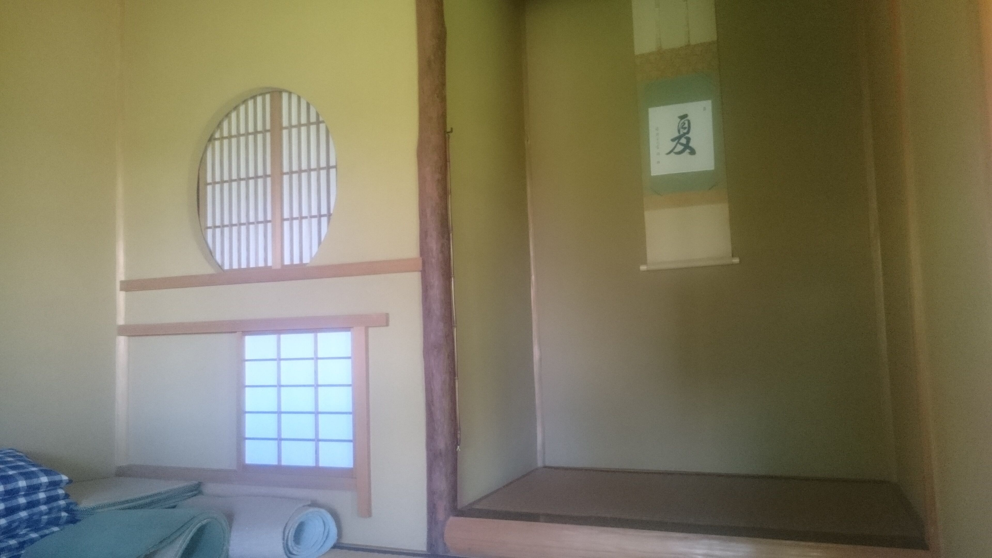 A traditional Japanese room with tatami flooring, a shoji screen, and a sliding door with calligraphy.