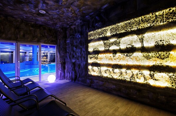 A spa room with a pool, a wall with a textured pattern, and a seating area with chairs. - Tristan Hotel & Spa (Sztutowo)