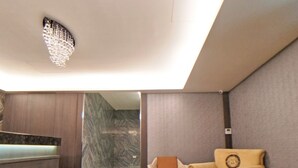 A modern interior with a marble floor, a reception desk, a sofa, and a small wooden table. - West.inn48 - Self Check-In Hotel (Taipei)