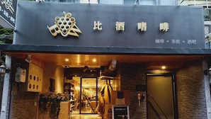 A hotel entrance with a modern design, featuring a logo and signage above the door. - West.inn48 - Self Check-In Hotel (Taipei)