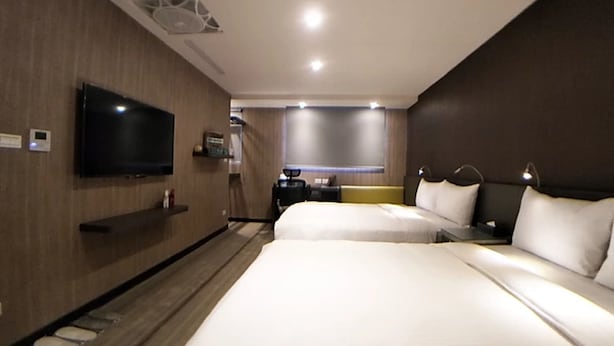 A hotel room with two beds, a TV mounted on the wall, a desk, and a window with blinds. - West.inn48 - Self Check-In Hotel (Taipei)