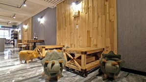A modern interior with wooden panel walls, marble flooring, and a central wooden table with chairs. - West.inn48 - Self Check-In Hotel (Taipei)