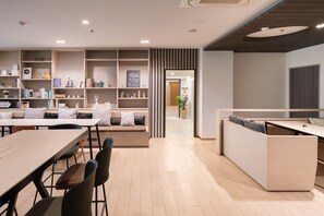 A modern kitchen with a dining area, built-in shelves, and a view into another room. - Samyan Serene Hotel (Bangkok)
