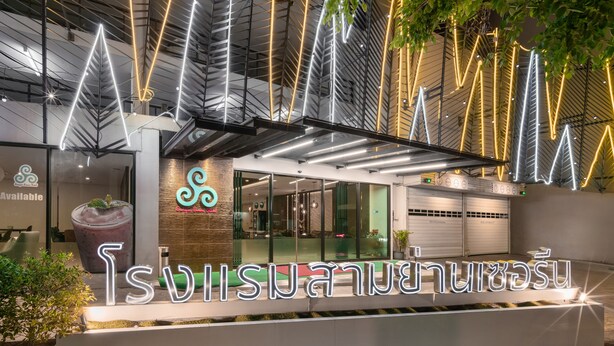 A modern building with a neon sign reading "Suwisaiyasai" and a glass entrance. - Samyan Serene Hotel (Bangkok)