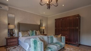 Ein Schlafzimmer mit einem großen Bett, einer Couch, einem Kleiderschrank und einer Deckenleuchte.