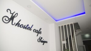 A wall with the text "Hostel Cafe Saigon" in a decorative font.