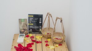 A wooden table with a basket, a box, and scattered flower petals.
