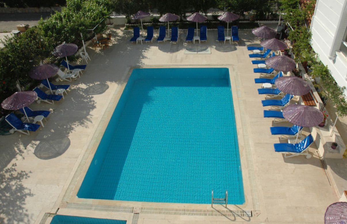 Una piscina al aire libre de temporada, sombrillas, tumbonas