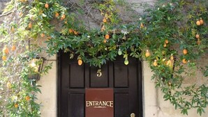 A black door with a sign reading "ENTRANCE" and a number "5" above it. - Candlesticks (Stamford)