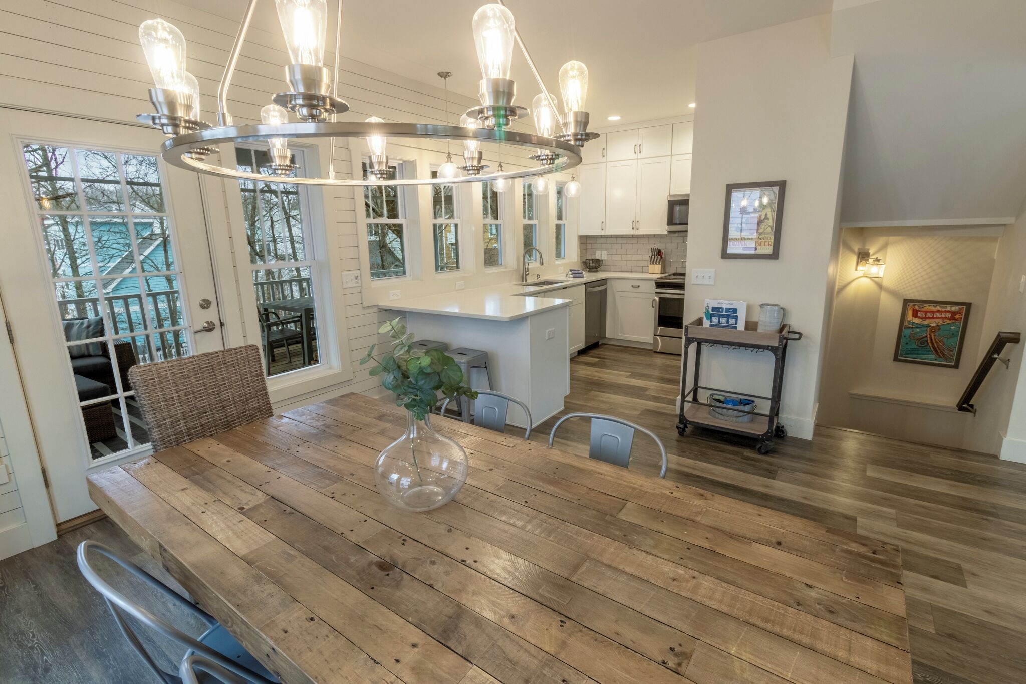 Una cocina moderna con suelo de madera, una isla central y una lámpara de techo original.