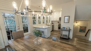 A modern kitchen with a wooden floor, a central island, and a unique light fixture. - Resort Home near Lake Michigan with Golf Cart (Michigan City)