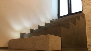 Eine Treppe mit Holzvertäfelung und einem beigefarbenen Tritt am unteren Ende.