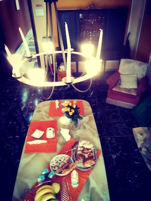 A marble table with food items and a vase of flowers. - B&B Al Calopinace (Reggio Calabria)