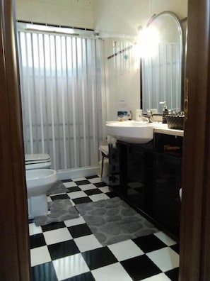 A bathroom with a toilet, sink, and mirror. - B&B Al Calopinace (Reggio Calabria)