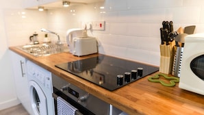 Una cocina moderna con lavadora integrada, un tostador y un microondas.