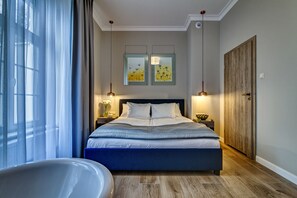 Un dormitorio con una cama grande, un armario de madera y dos cuadros en la pared.