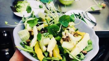 A bowl of salad with various greens and vegetables.