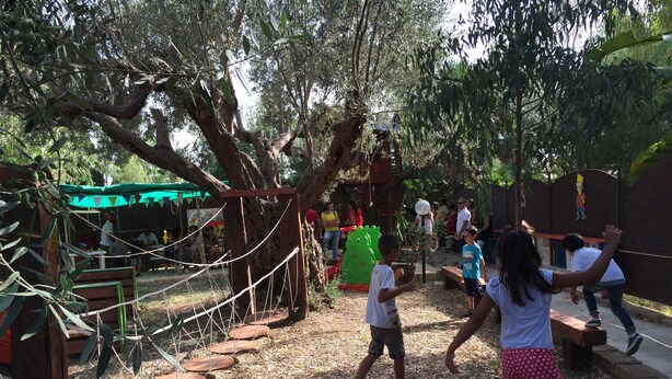 A playground with a rope bridge, climbing structures, and a green tent. - Camping Valle Dei Templi (Agrigento)