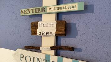 A wall with various signs, including 'cote sauvage' and 'sentier du littoral 200m'.