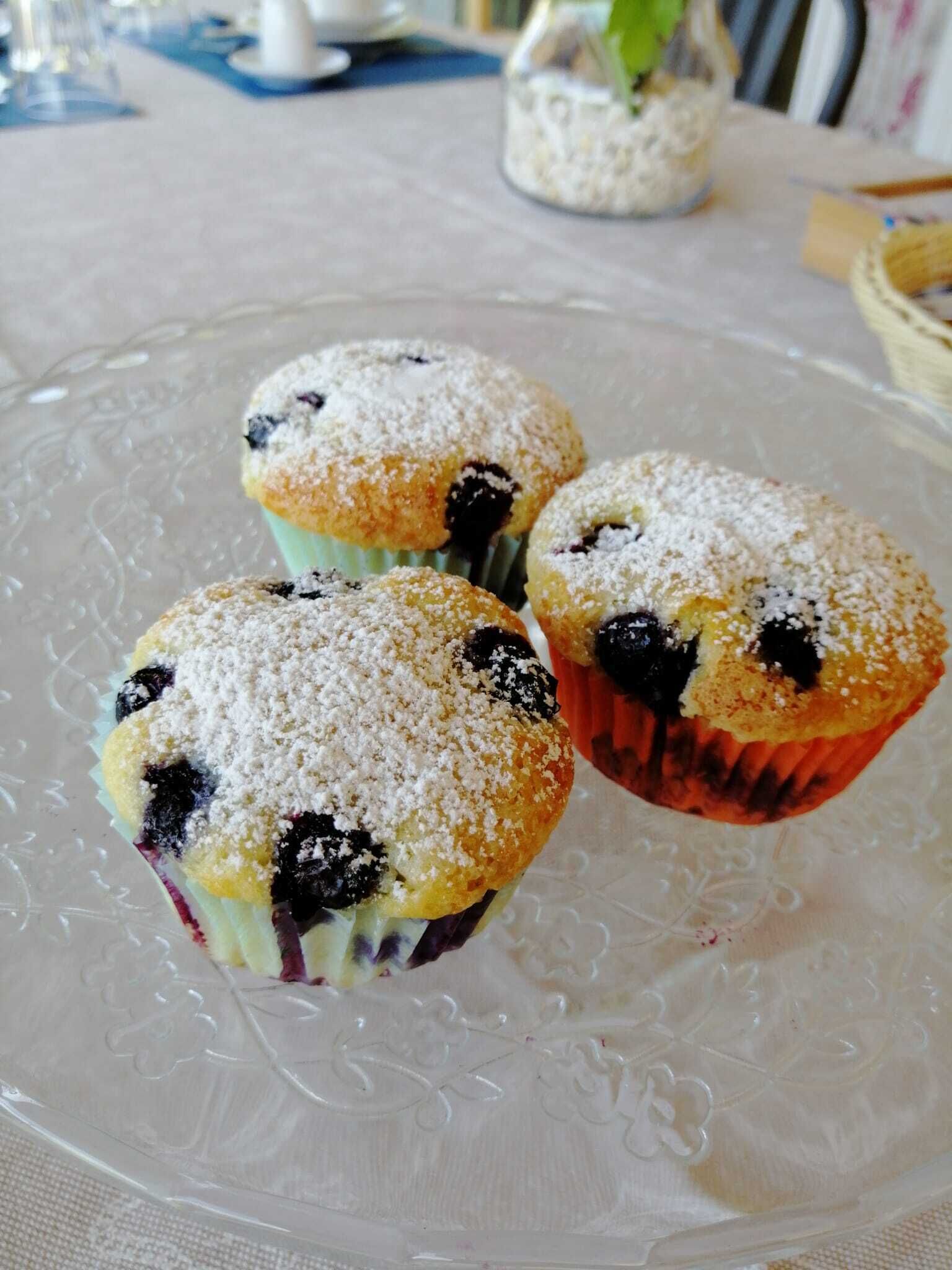 Tres muffins sobre un plato de vidrio transparente.