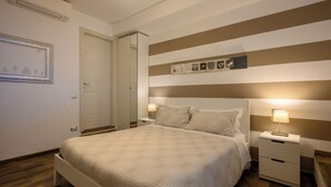 A neatly arranged bedroom with a bed, bedside tables, and a mirror. - Il Murice B&B (Vezzano Ligure)
