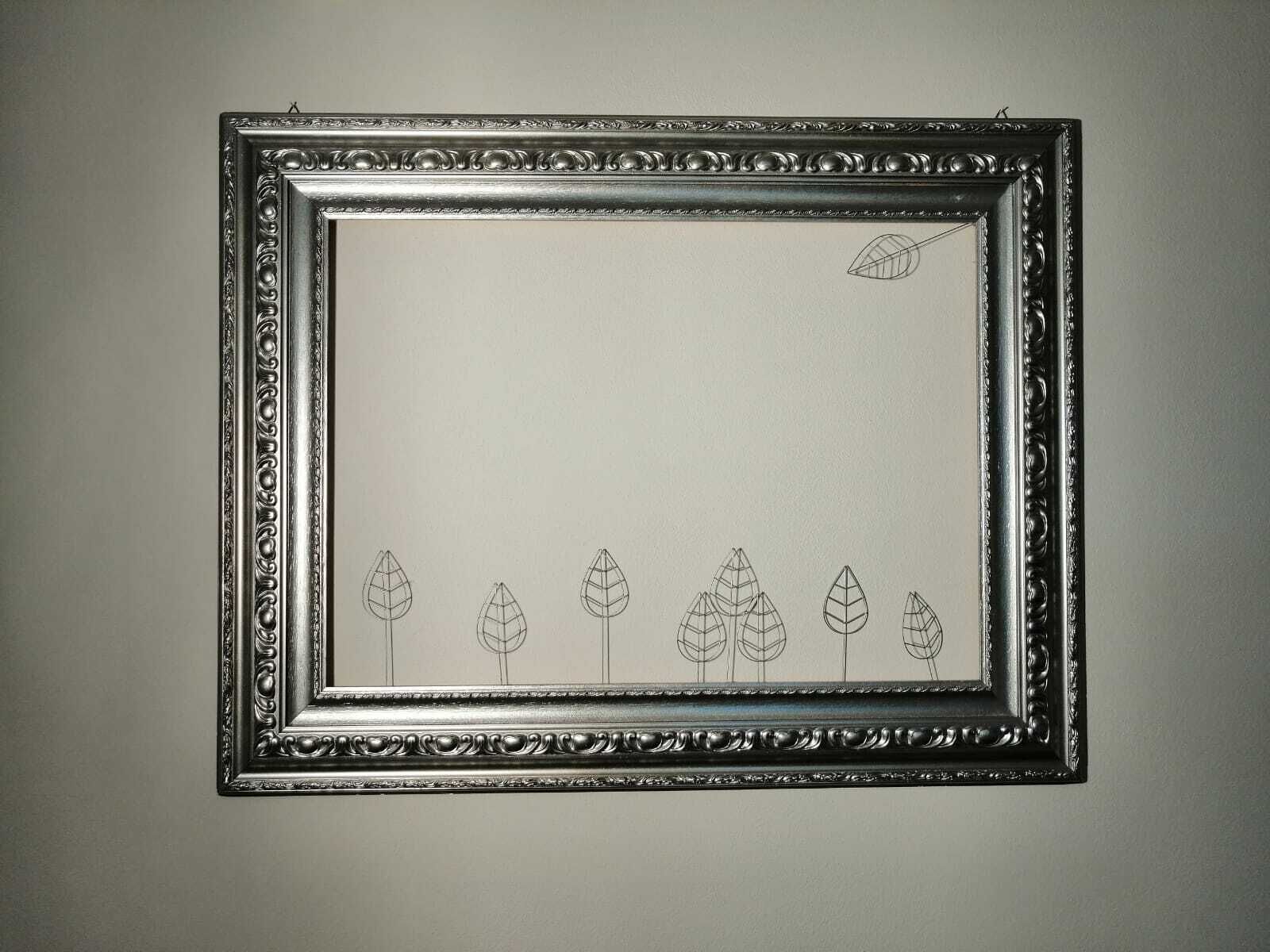 Una cornice da parete con un design elaborato, caratterizzata da una serie di contorni a foglia.