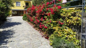 A yellow building with a stone pathway leading to a door. - Il Murice B&B (Vezzano Ligure)