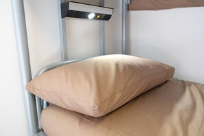 A bed with beige bedding and a control panel above it. - Black Isle Hostel (Inverness)