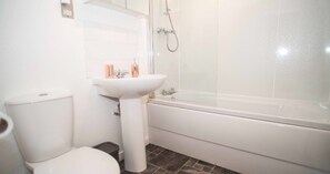 A bathroom with a toilet, sink, and bathtub.