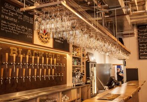 A bar area with multiple beer taps and a selection of glasses hanging from the ceiling. - Black Isle Bar and Rooms (Inverness)