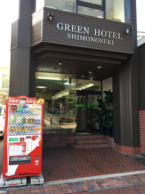The exterior of the Green Hotel Shimonoseki with a vending machine in front. - Green Hotel Shimonoseki (Shimonoseki)