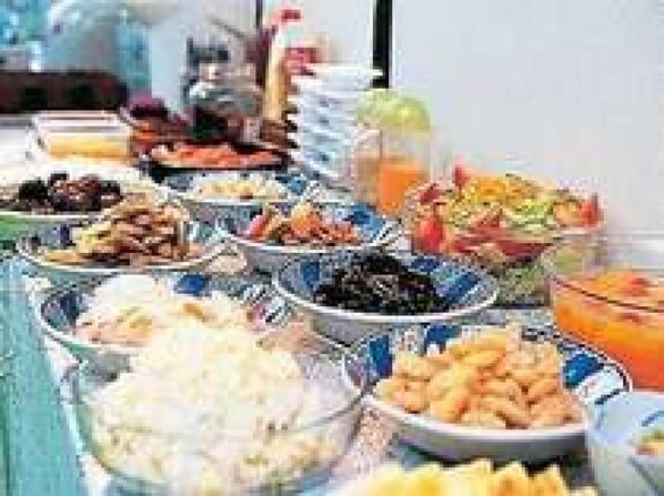 A buffet with various dishes including fruits, vegetables, and other food items.